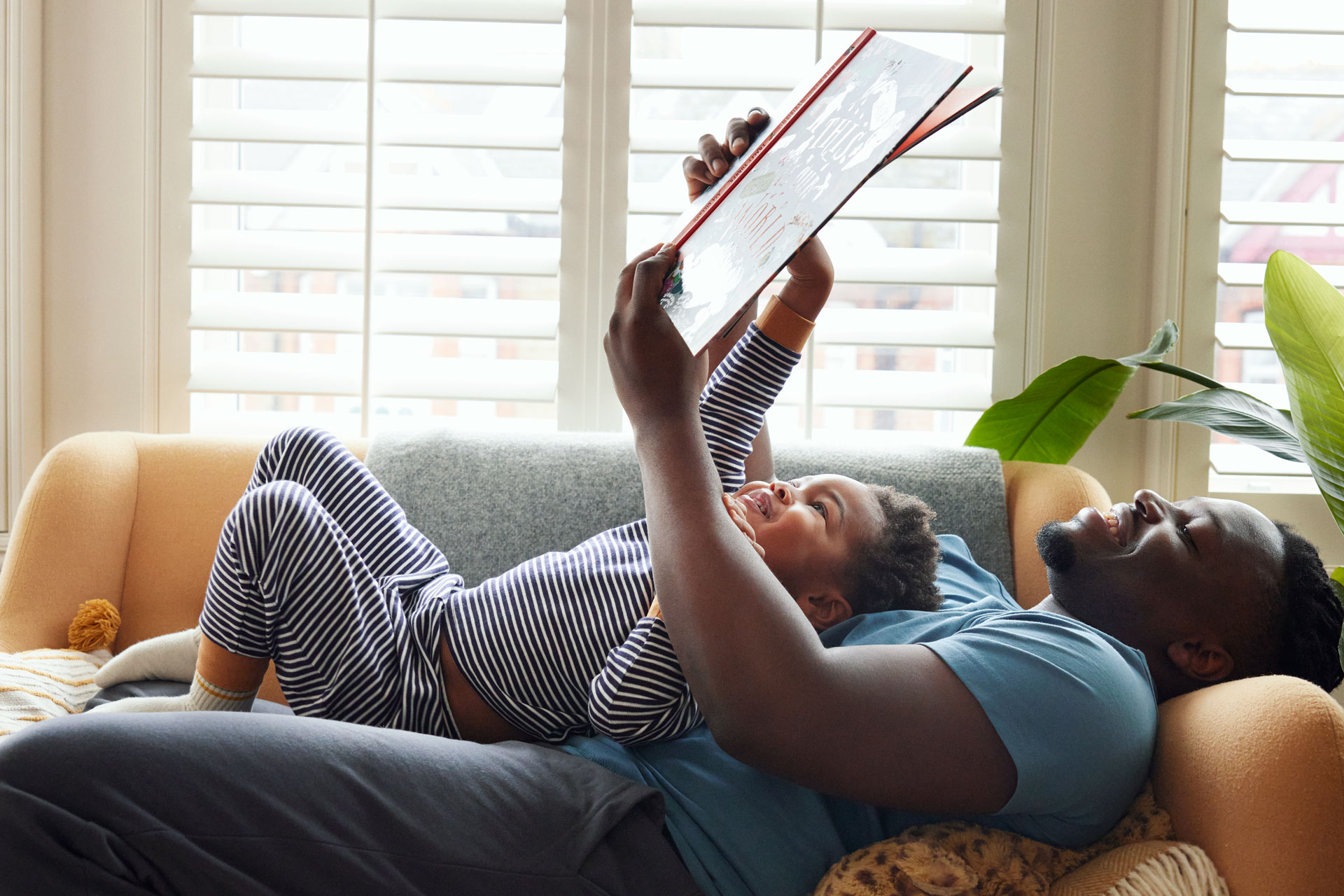 a father and son read a book together, from 'The Moments Economy' Report by John Lewis