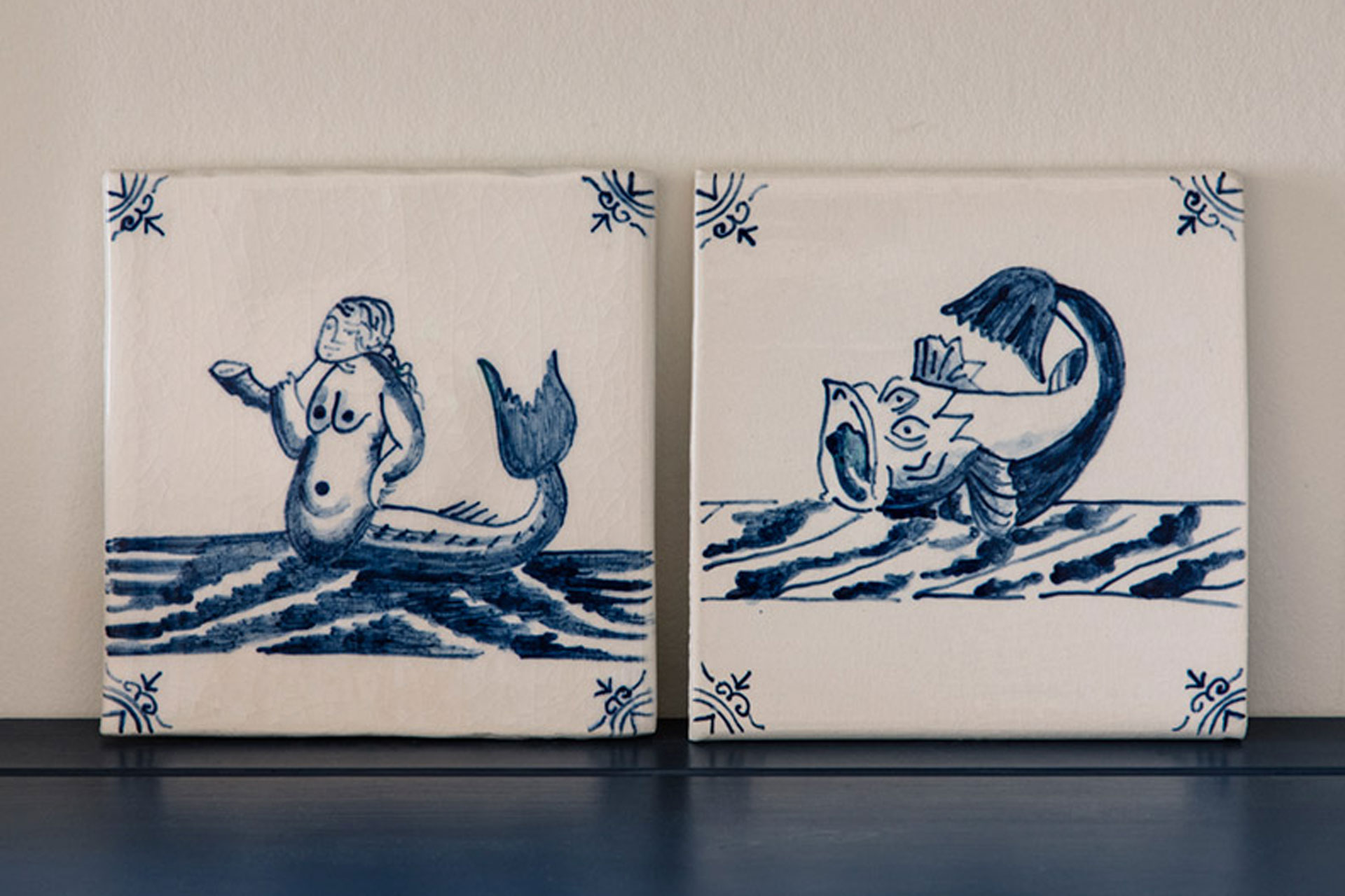 hand painted sea creatures in blue paint on a delftware tile by Plain English