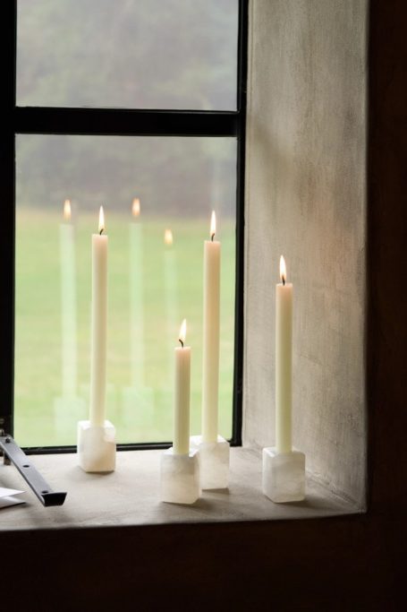 Cream candles on windowsill