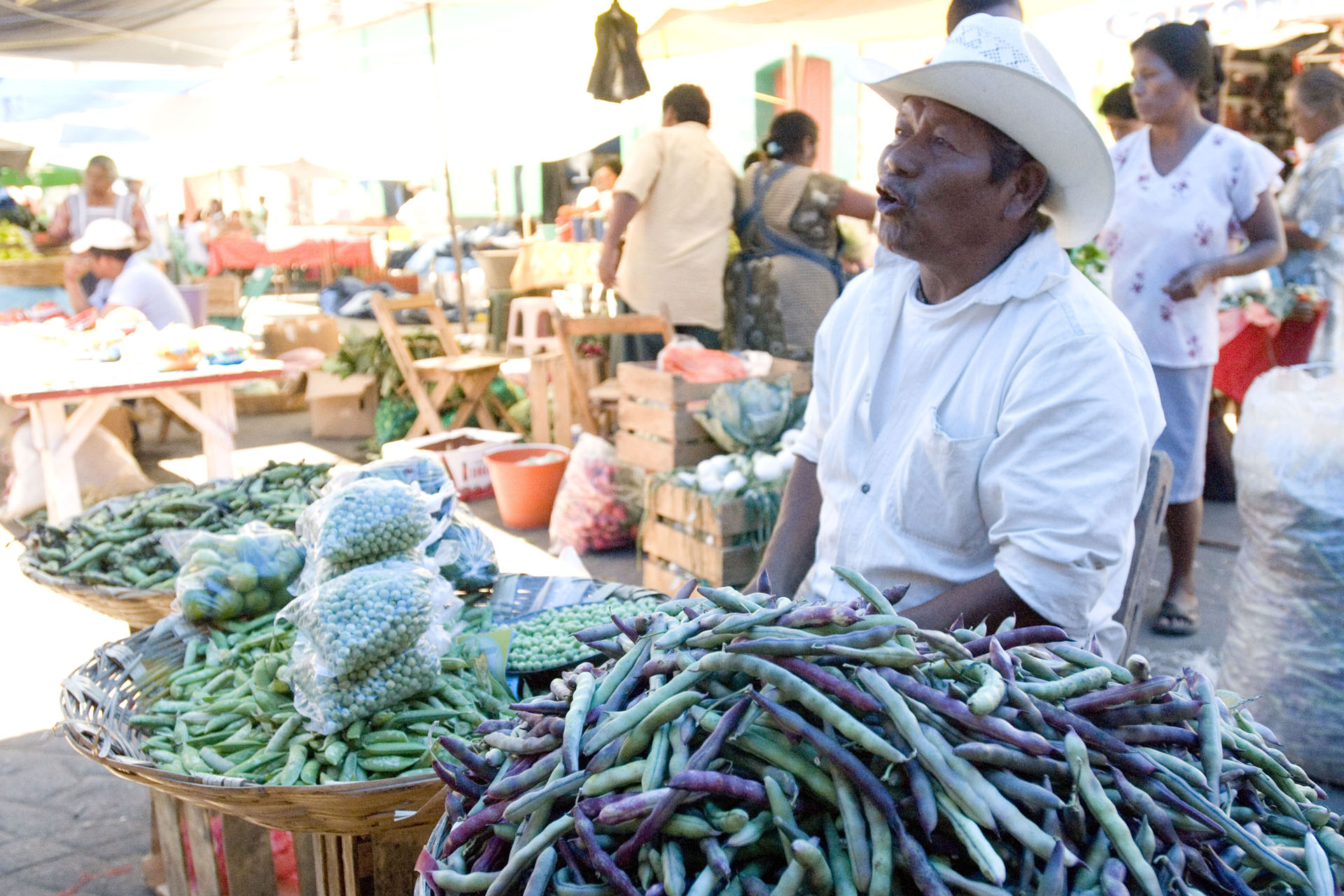 a man at a food market wit beans in oaxaca