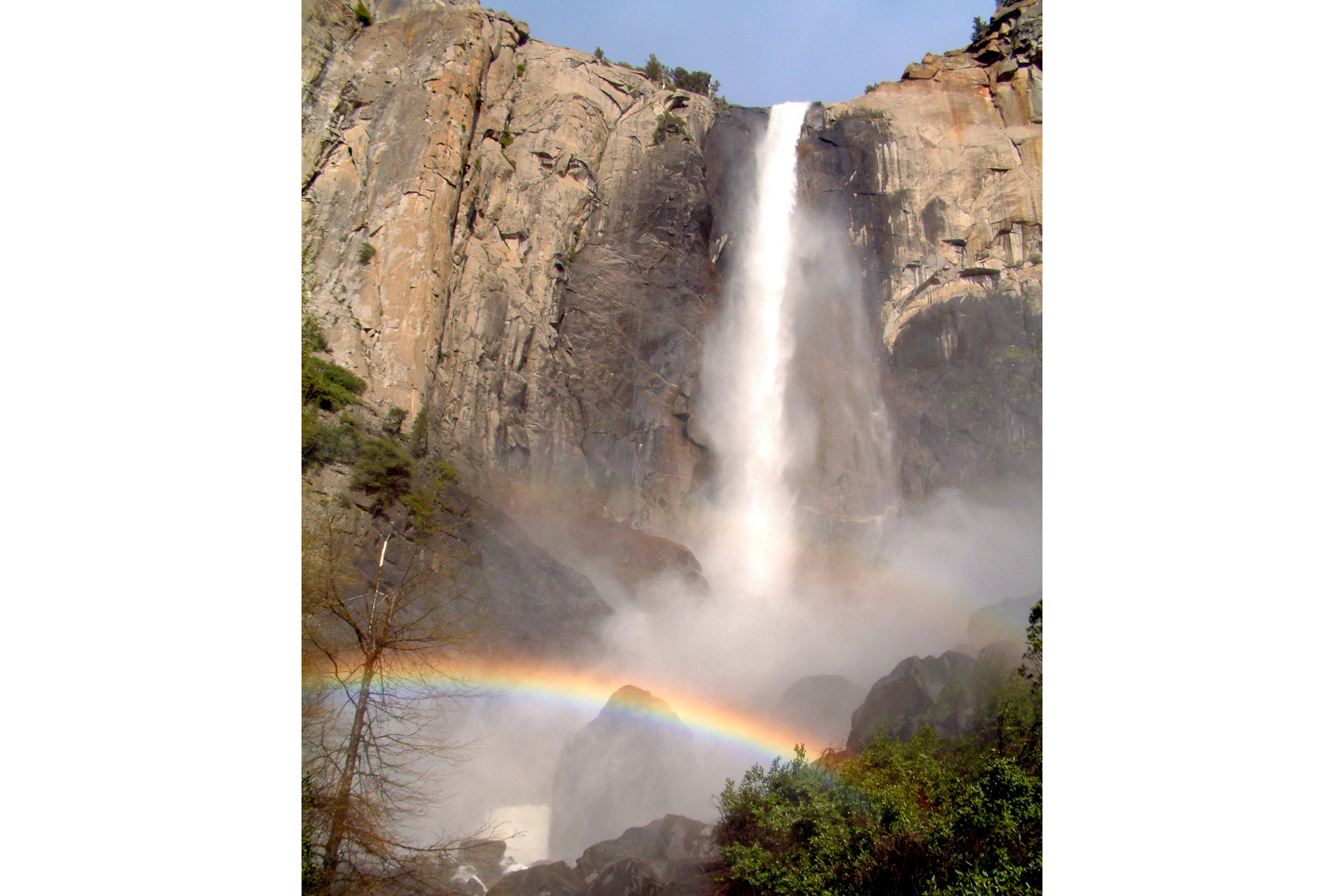 a waterfall with a rainbow at the base