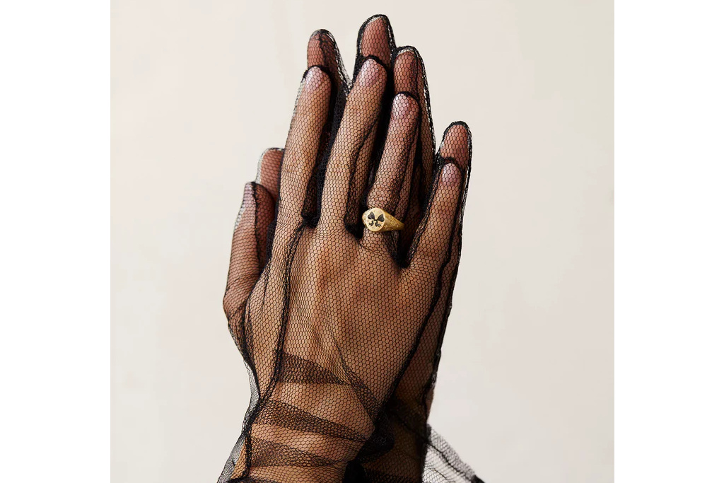 Black gloved hand wearing ring