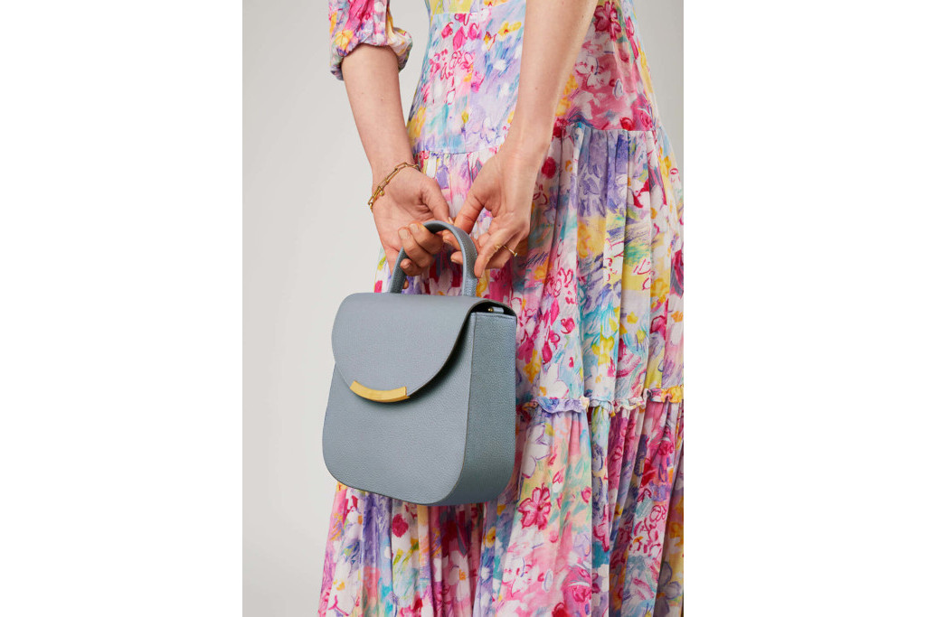 Close up of someone in long floral dress holding blue bag - brands the royals love