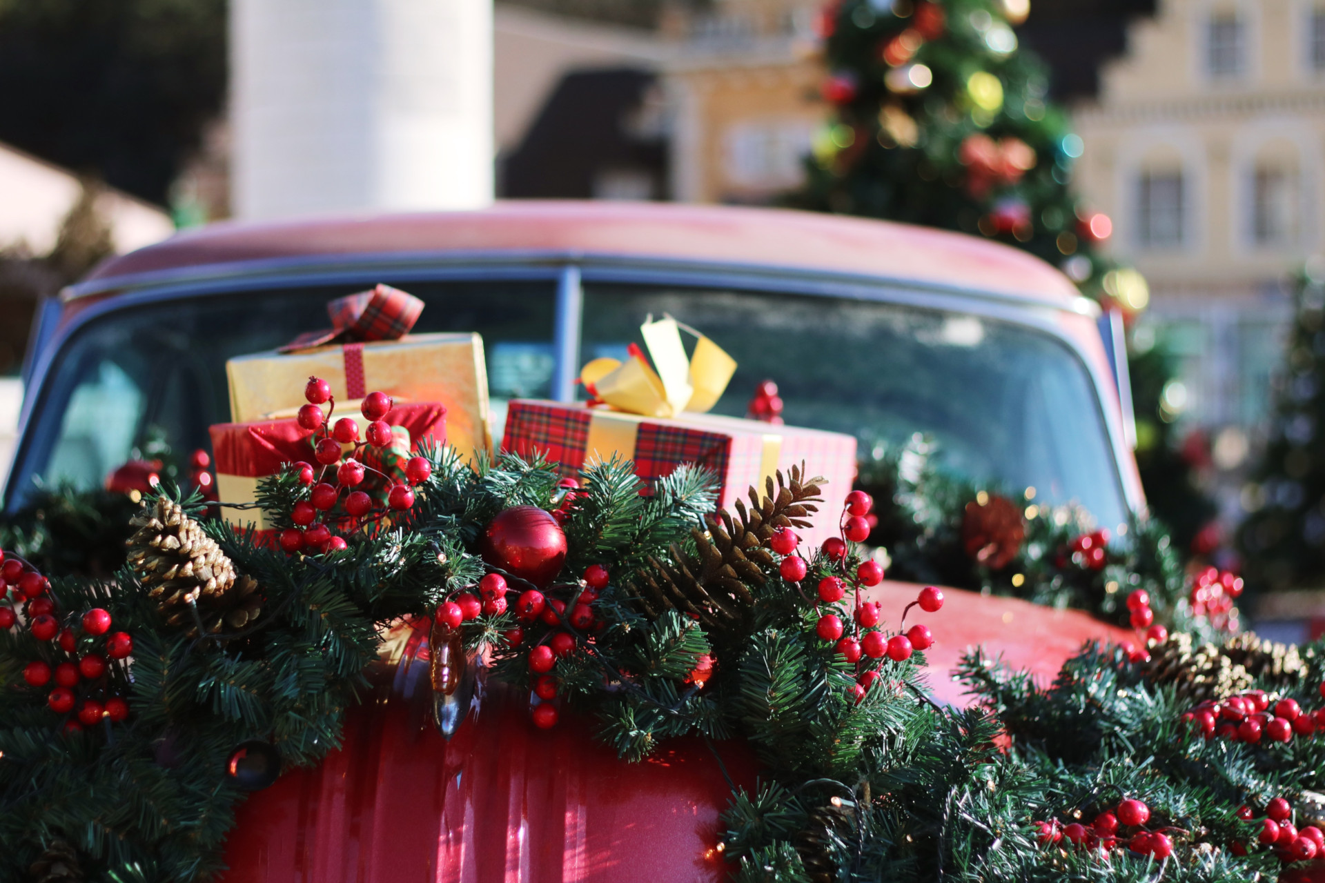 Red car with presents and wreaths on the bonnet