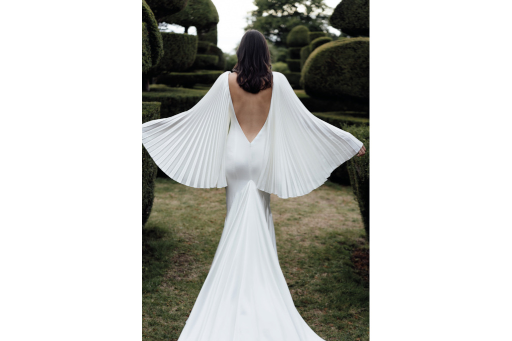 Back of woman wearing a white dress with open back