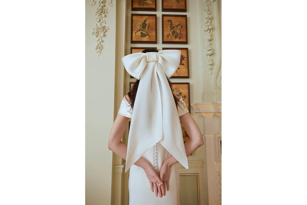 Back of woman wearing large white bow in her hair