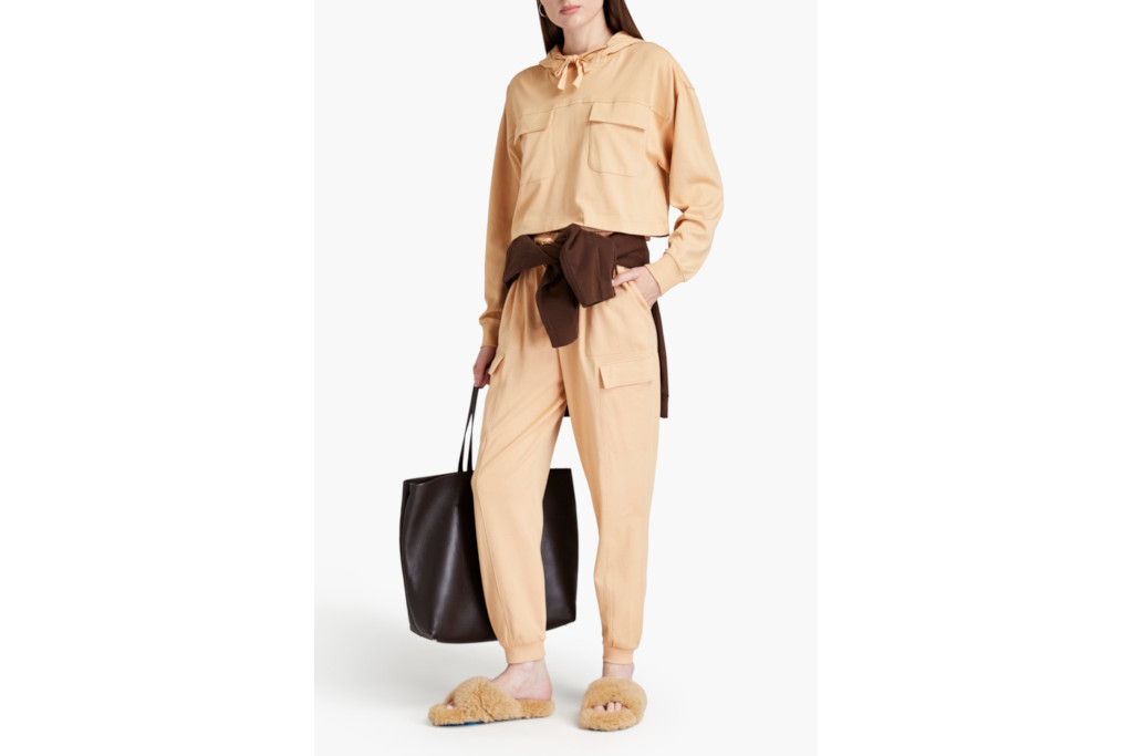 Woman in light orange hoodie and joggers