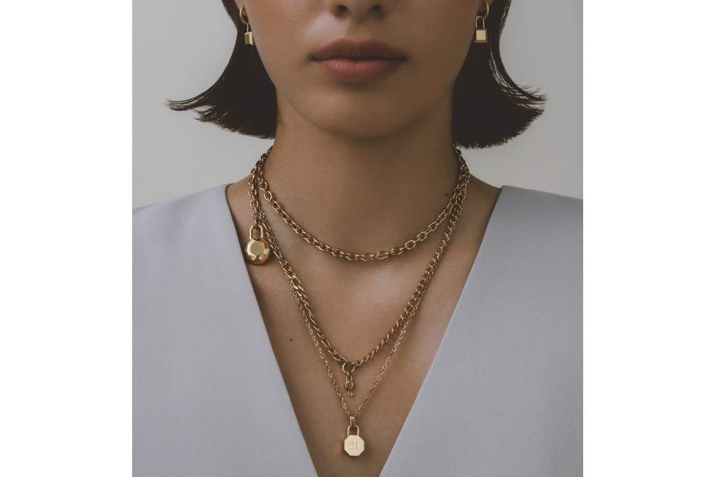 Close up of model's neck with gold necklaces layered together