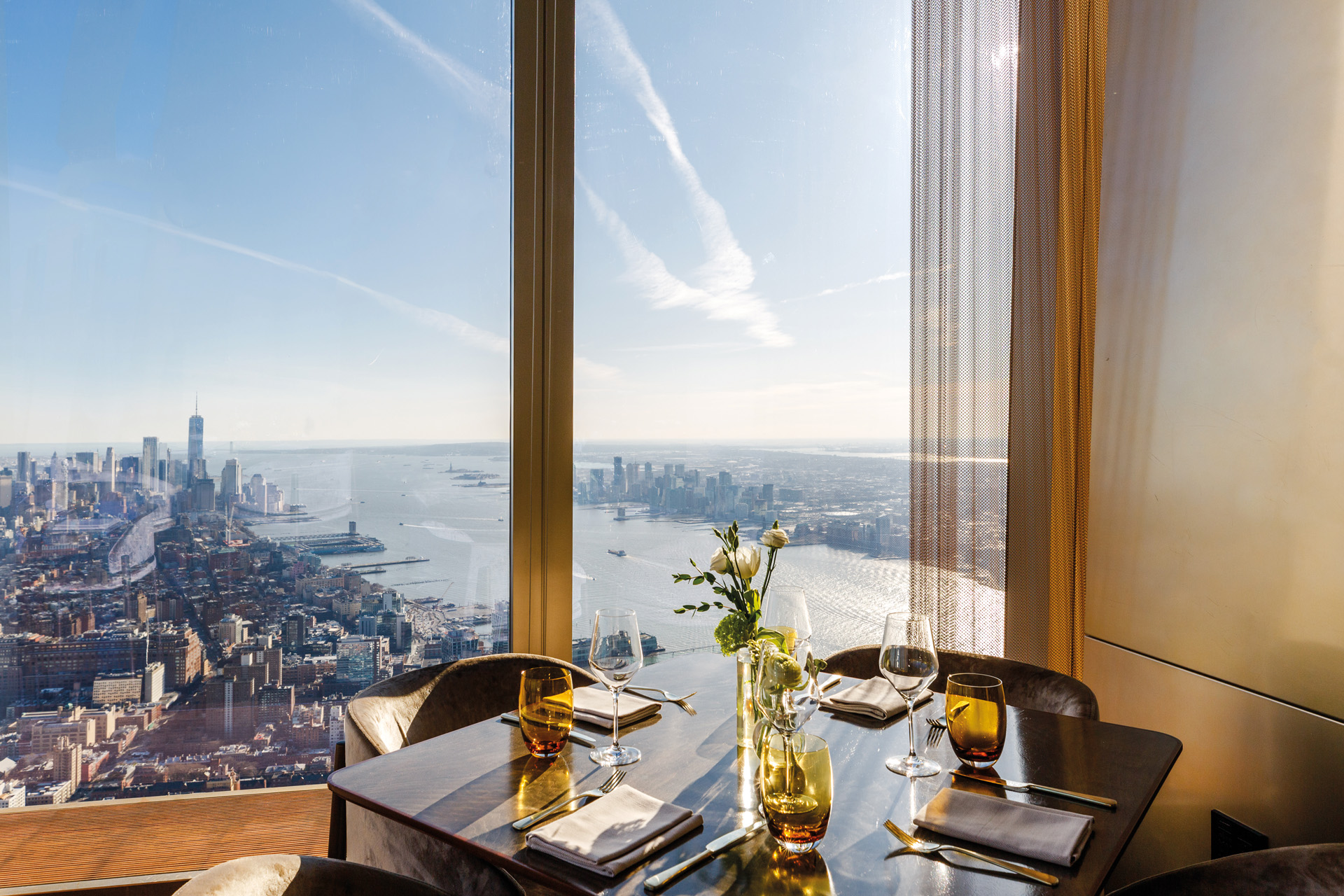 a layed table in front of panoramic window view over new york city