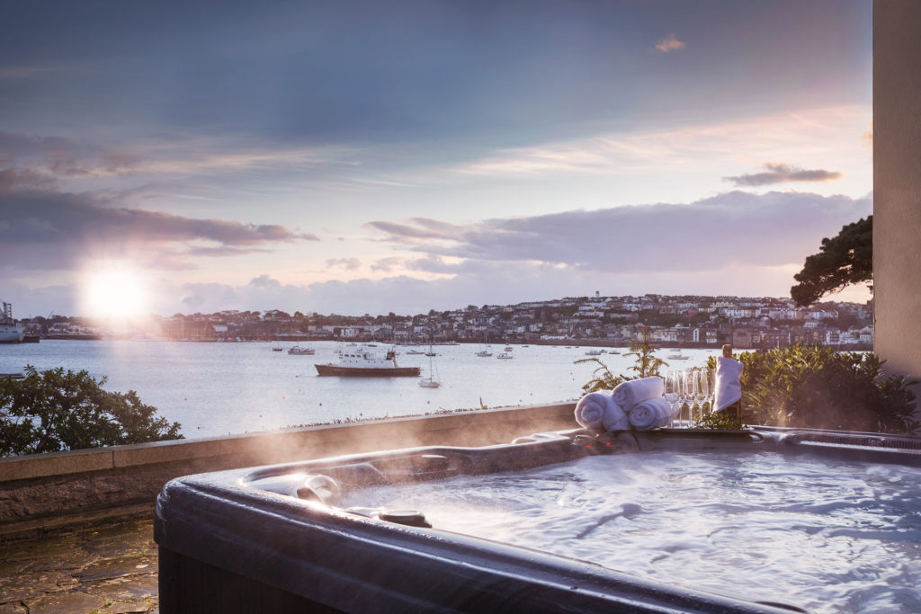 a steaming hot tub overlooking boats in a port