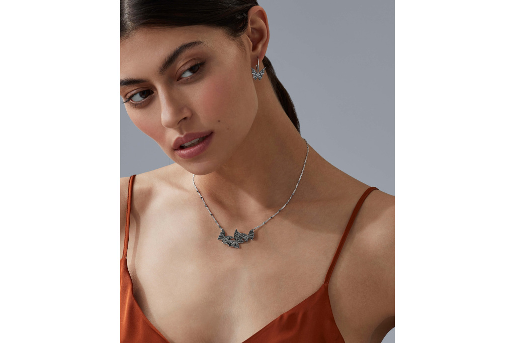 Woman wearing black moth necklace and earrings