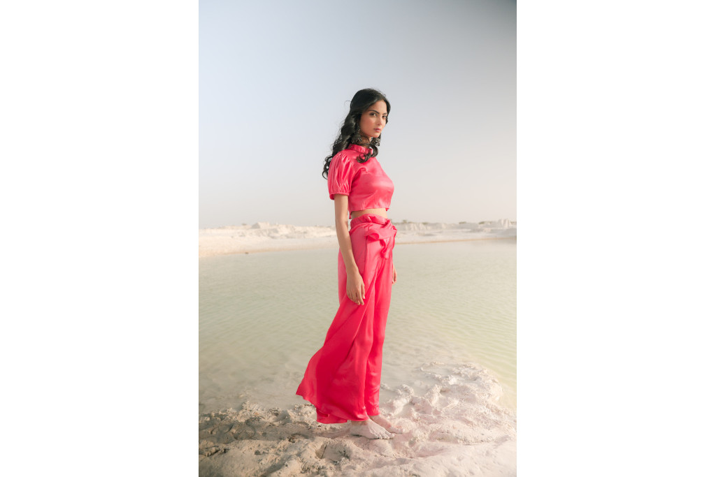 Woman stood in pink silky top and trousers