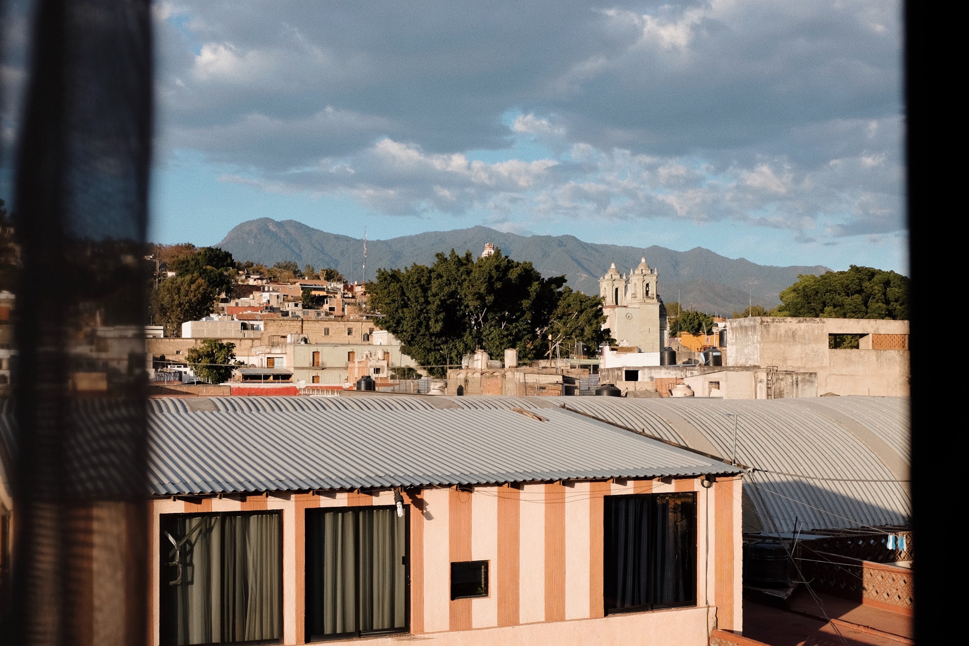 looking over buildings in oaxaca towards a mountain