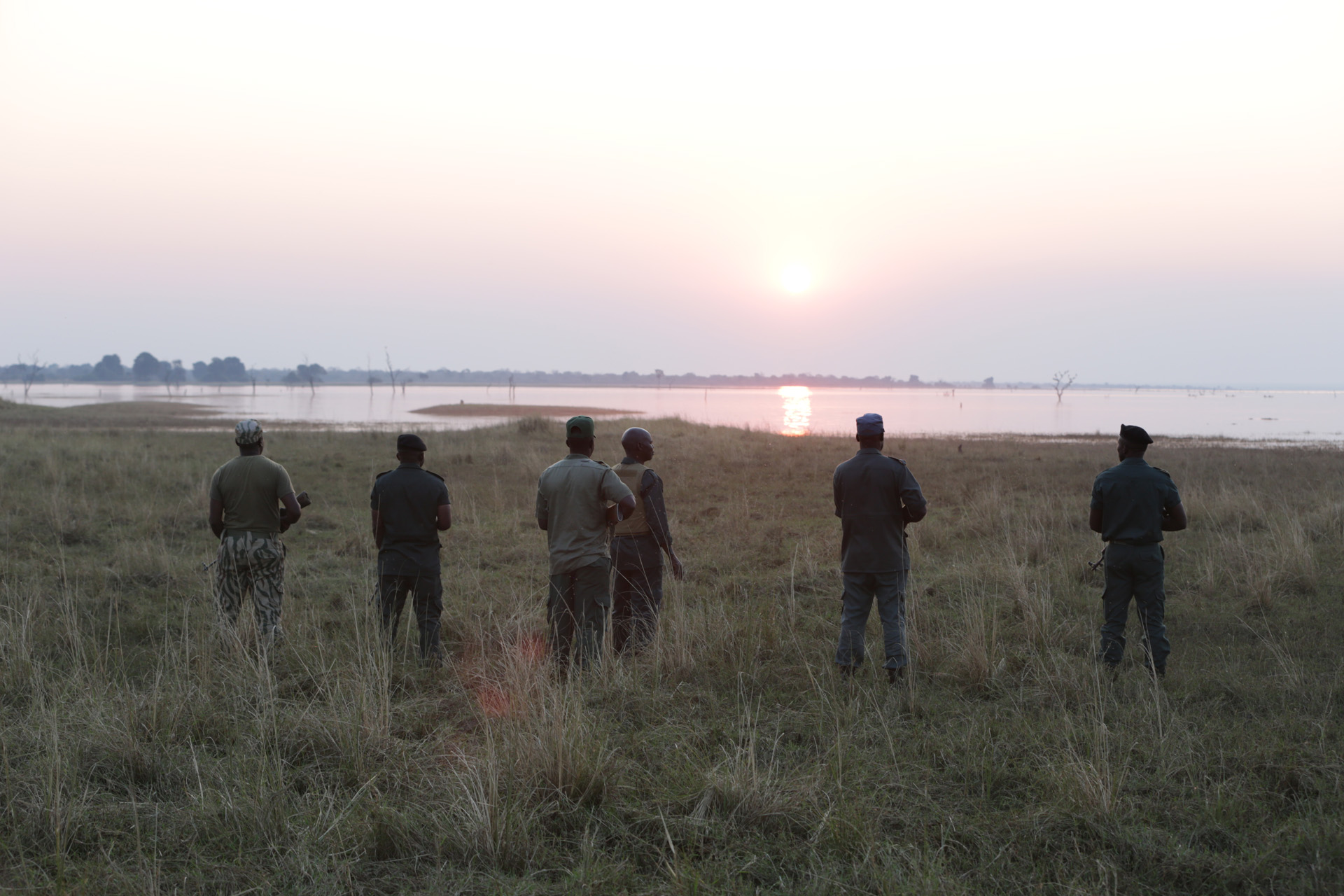 Neddy Mulimo and other wildlife rangers walking towards a sunset in Africa
