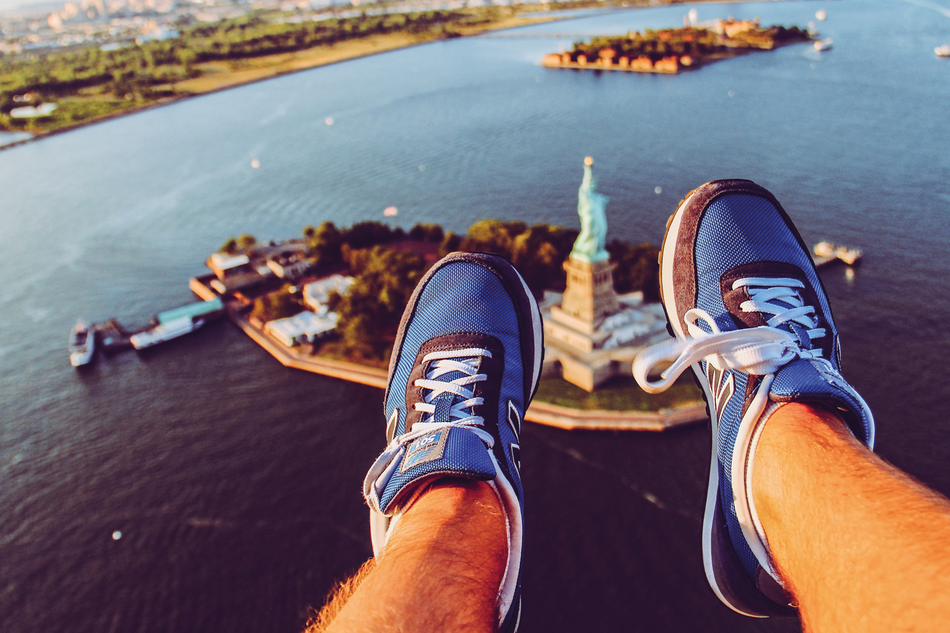 looking down on the statue of liberty with feet in the foreground