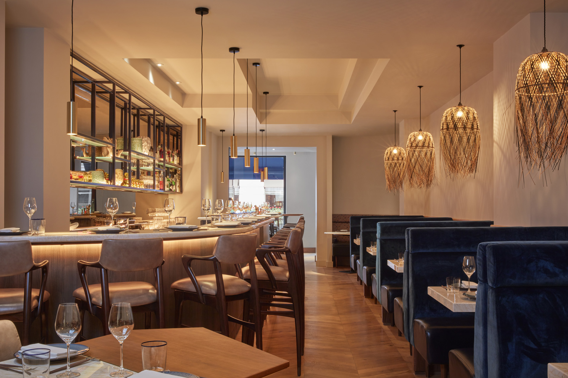 a long bar and a line of velvet booths at Bar Des Prés