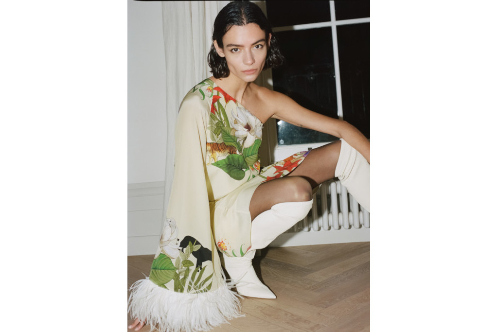 Woman crouched in party dress and white boots