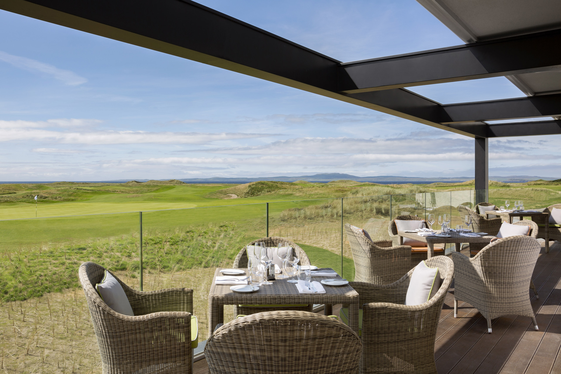 tables on a terrace overlooking a golf course