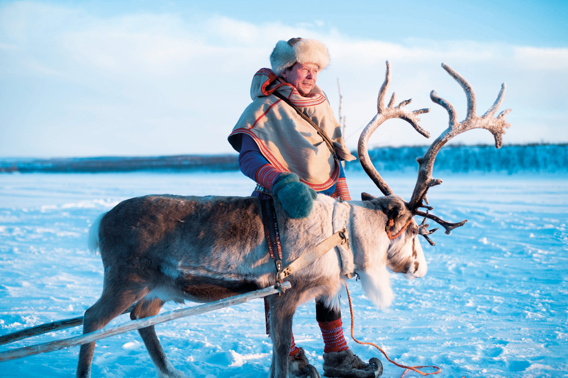 a man with a reindeer on ice