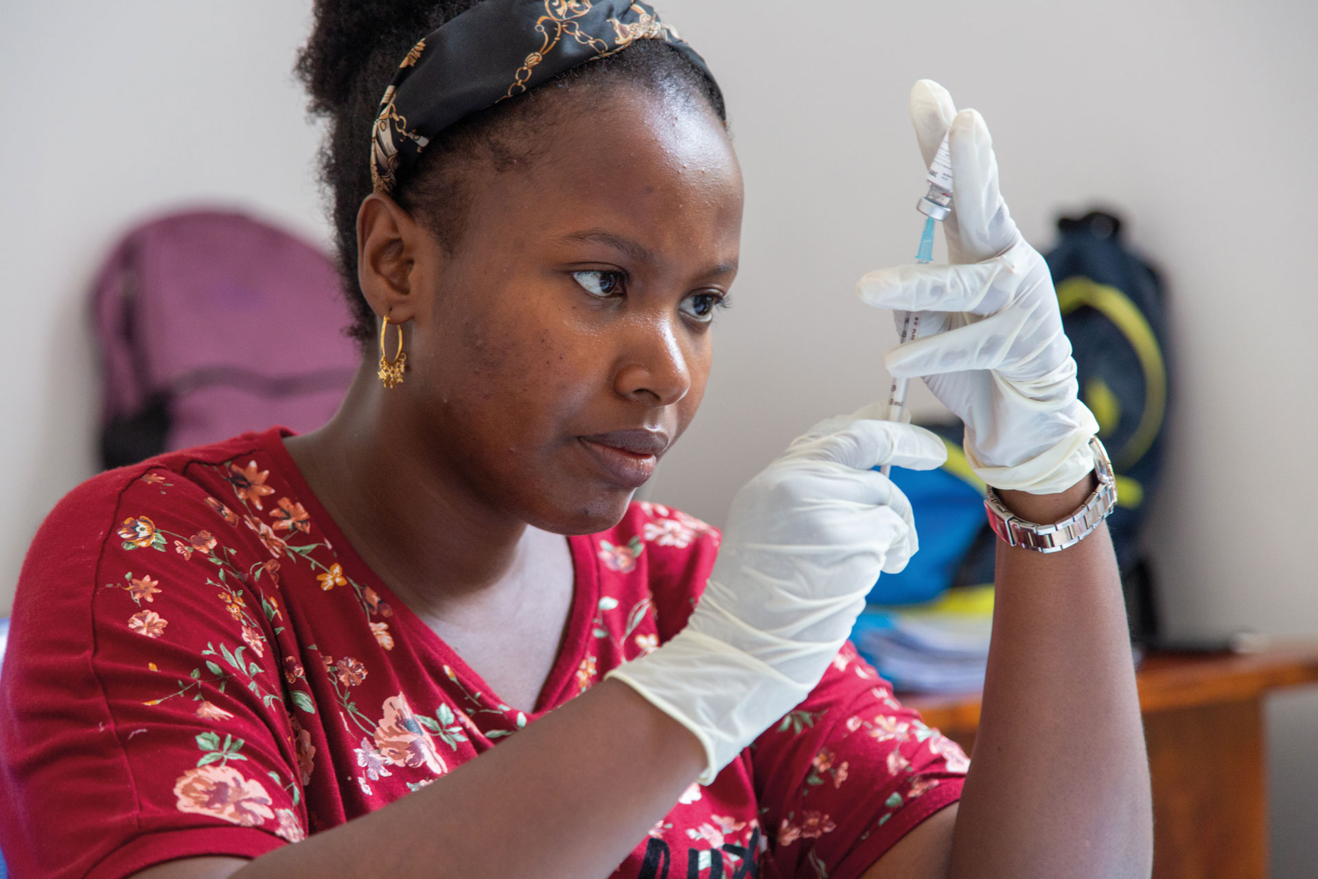 Malaria Vaccine - vaccine administrator checks needle 
