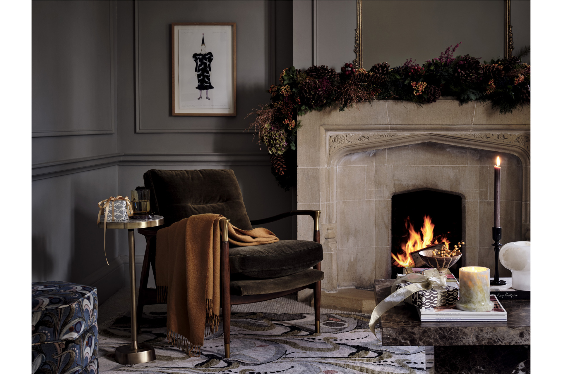 a green velvet armchair with mustard throw and festive fireplace