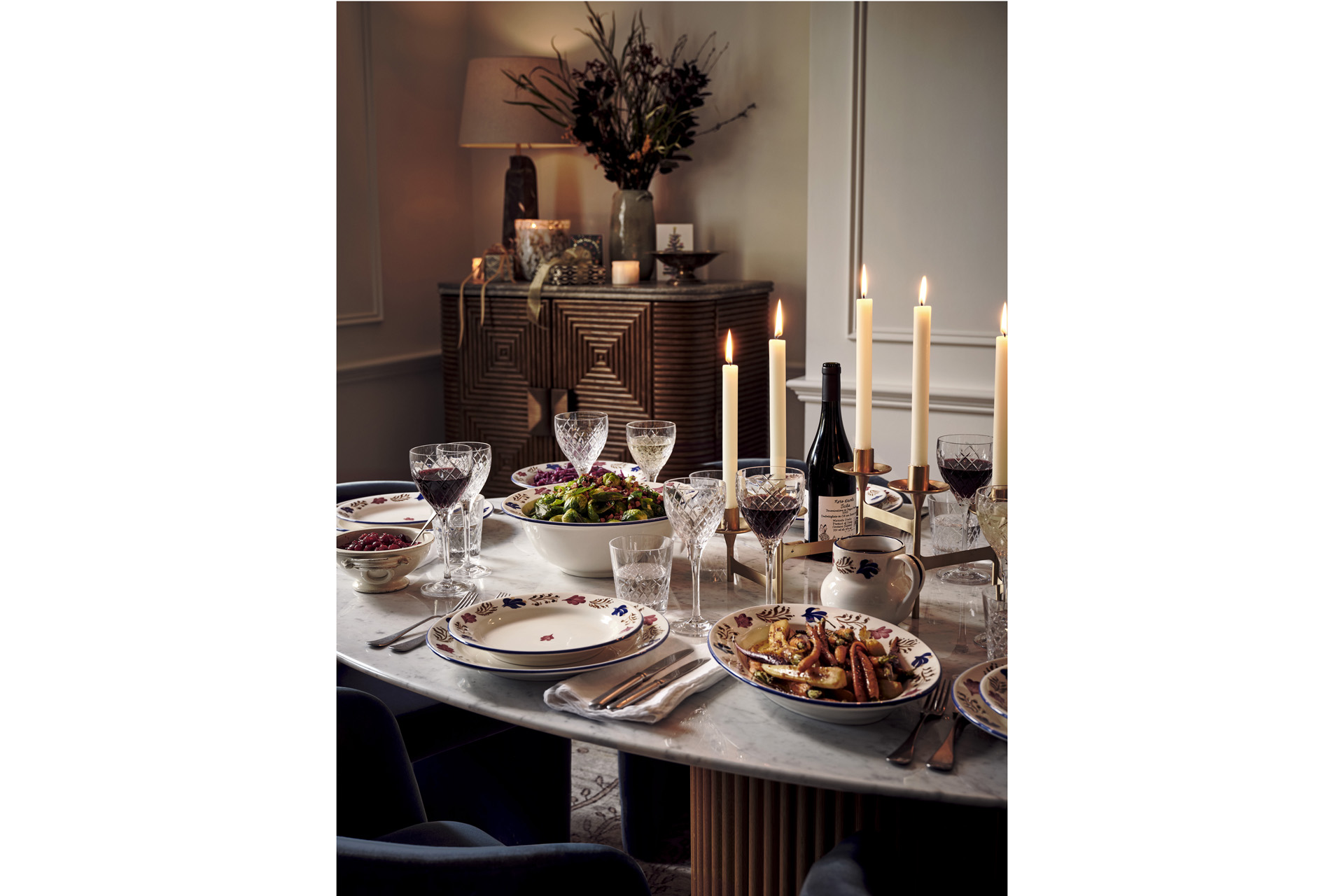 a festive table set with plates, food and candles