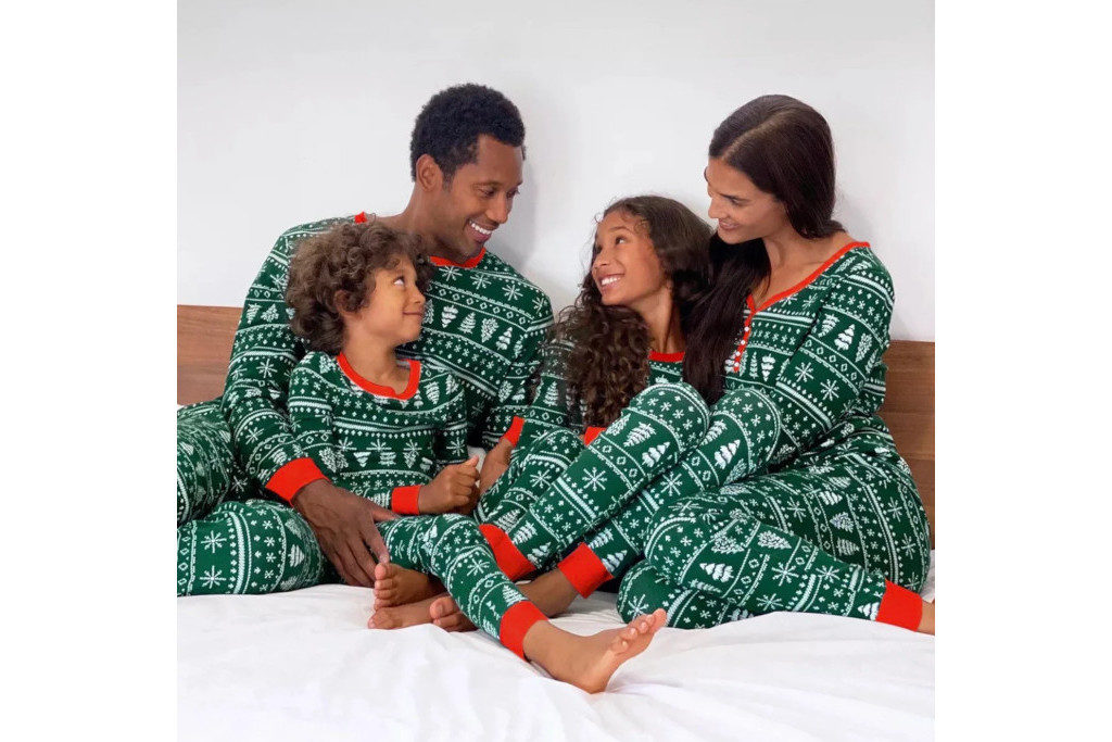 Family in green pyjamas sat in bed together