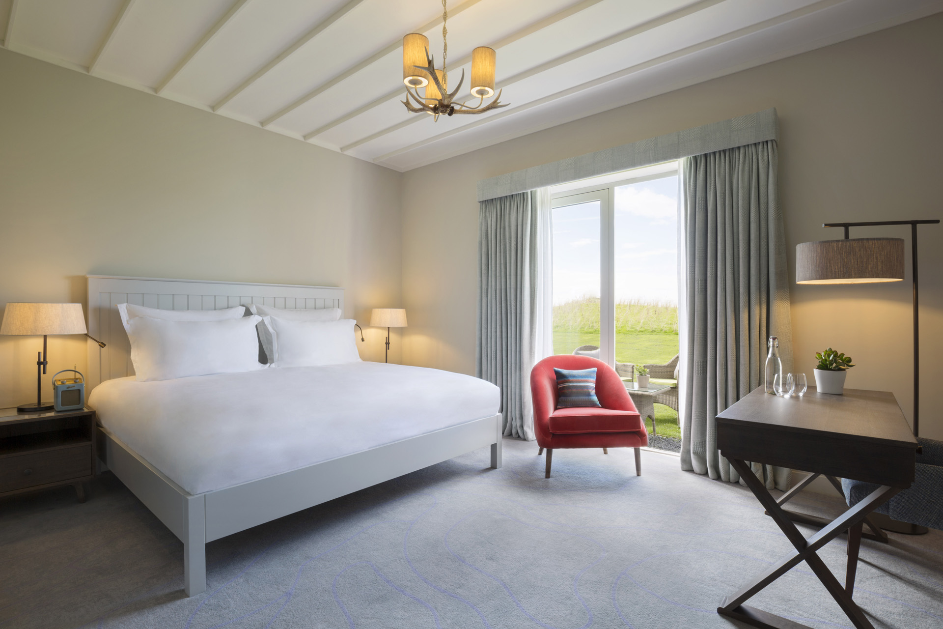 a hotel bedroom with large bed and double doors opening to a patio
