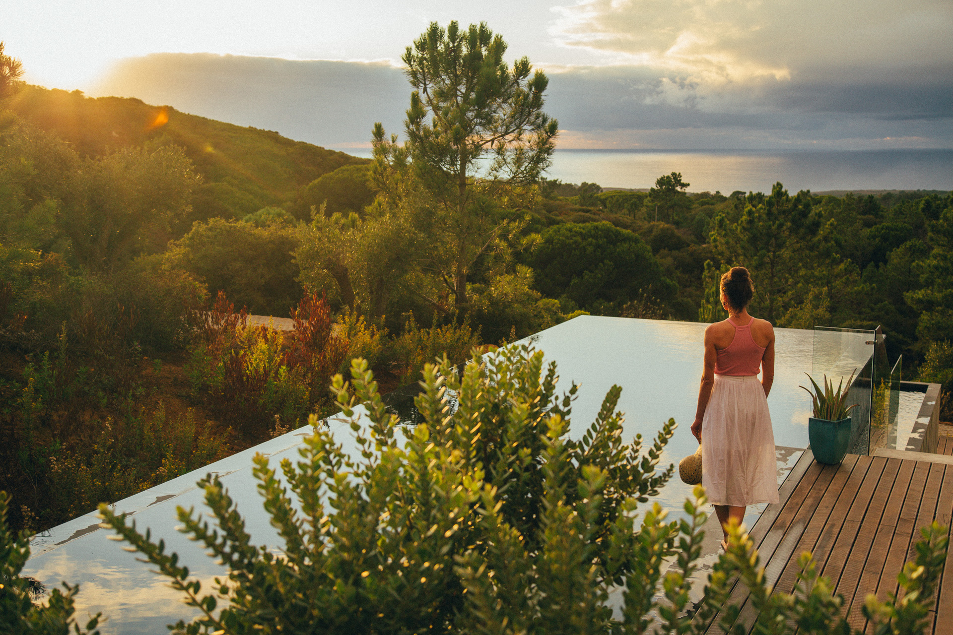 golden hour over the swimming pool at Villa Epicurea at someone stands alongside it in a towel