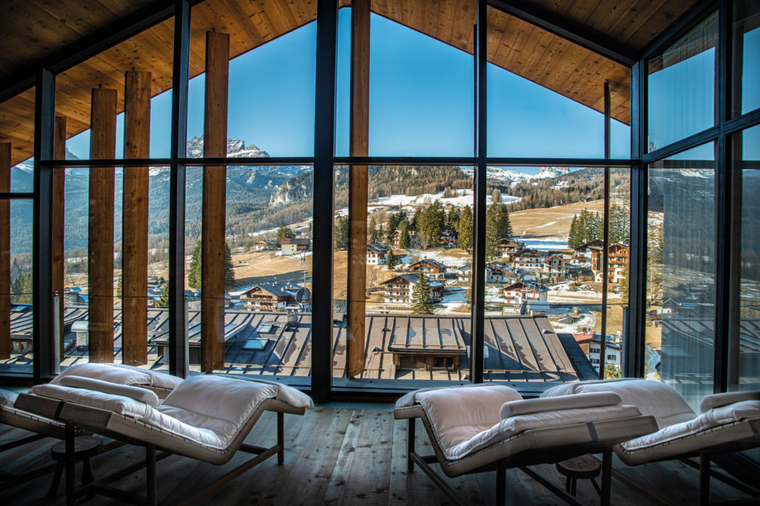 sun loungers looking out a large window over the dolomites ski resort