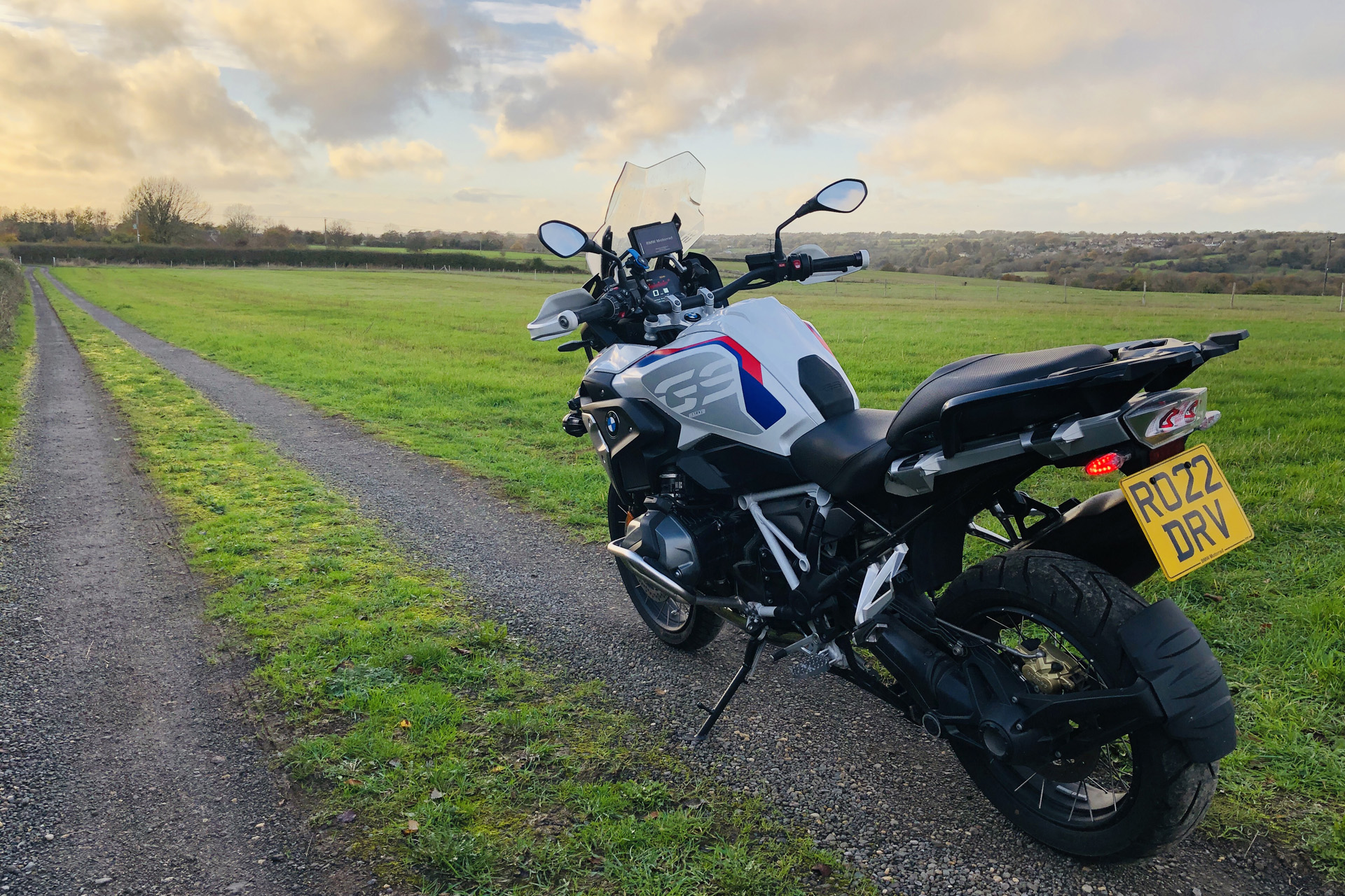 the BMW R1250GS at dusk on a field with little pathway