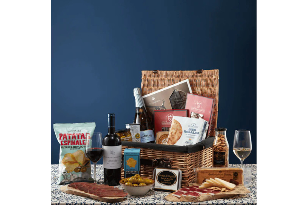 Hamper with drinks and snacks on blue background