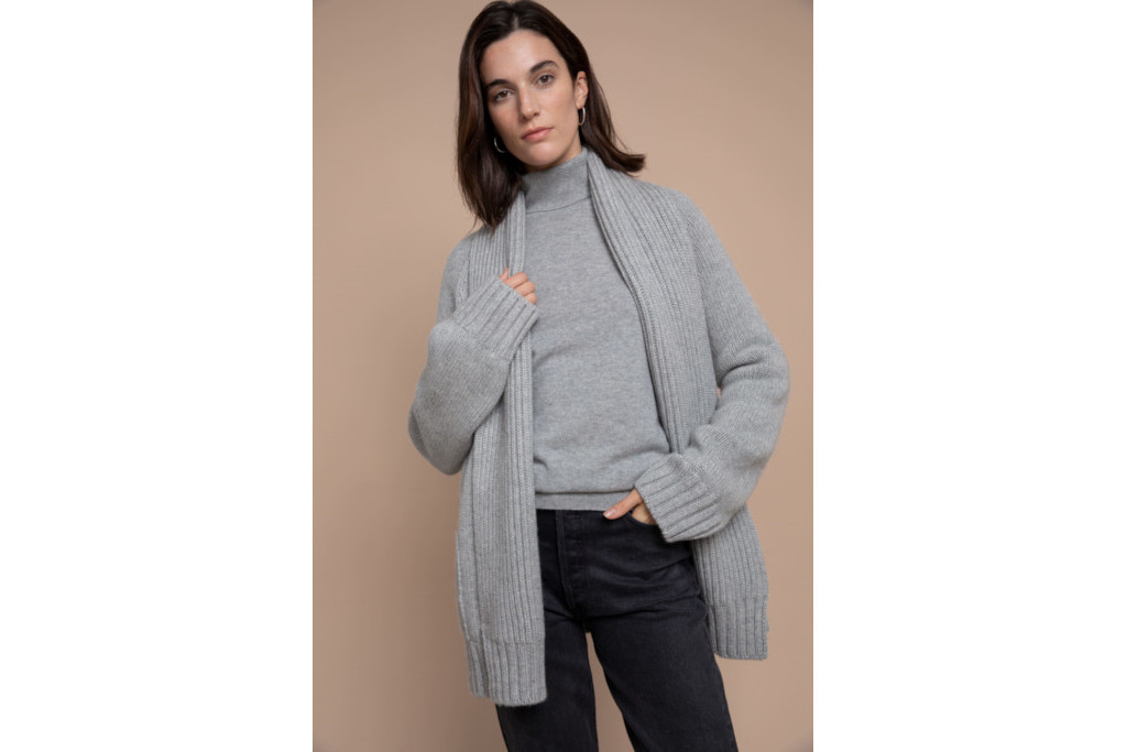 Woman in blue cardigan and top, and black trousers