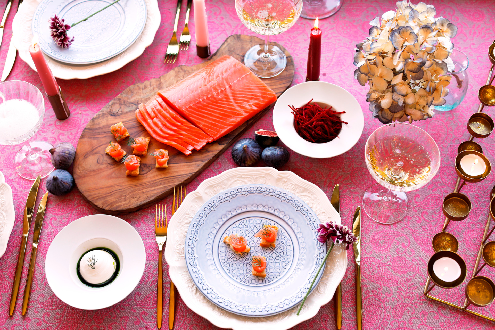 Spread of salmon canapes on pink surface