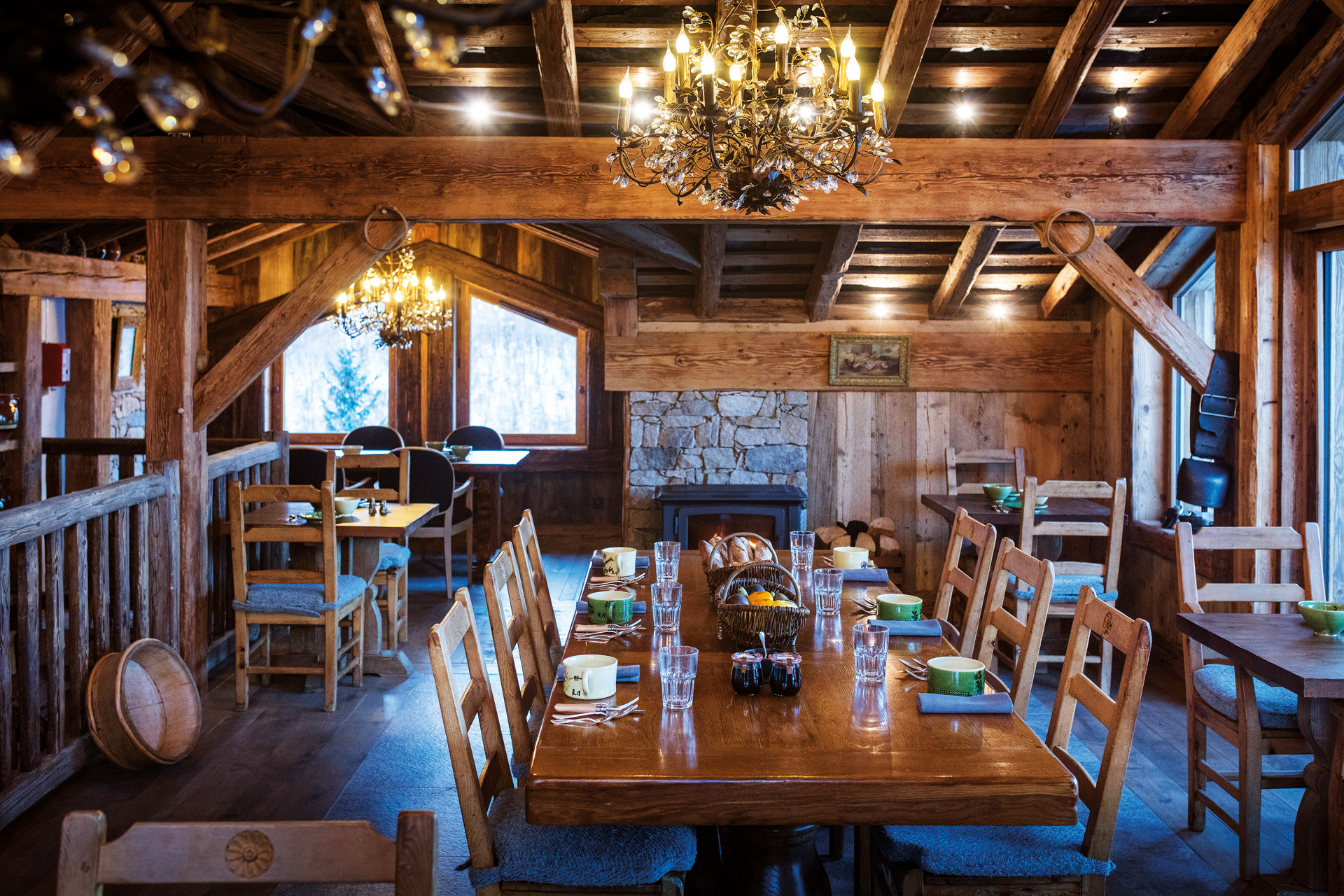 a wood clad dining room with glowing chandelier