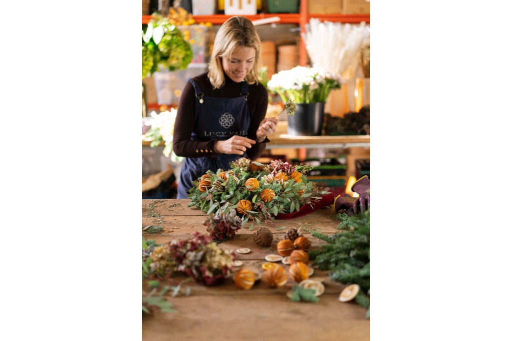 Woman at table building a Christmas wreath