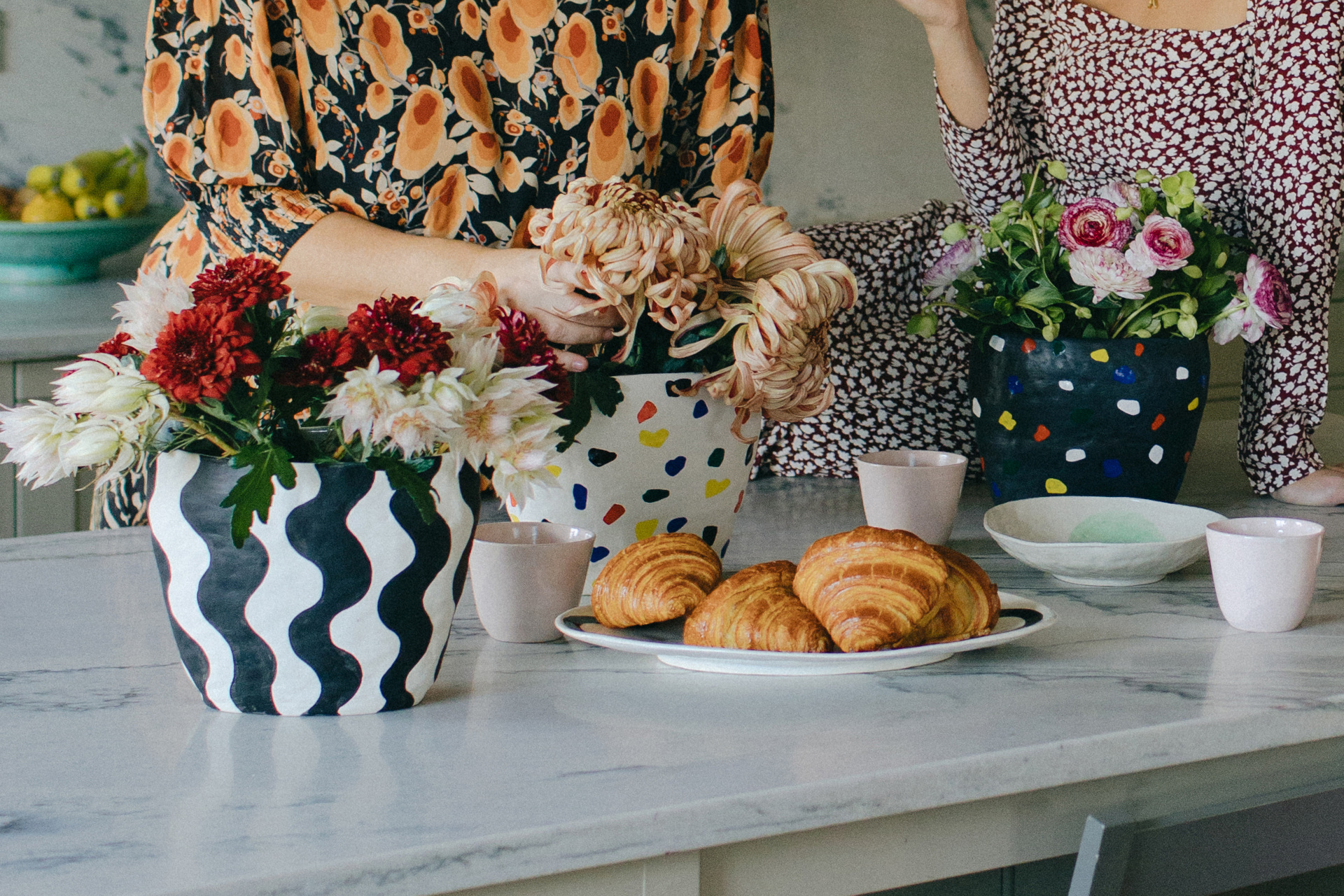 Spread of vases, bowls and pastries on marble counter