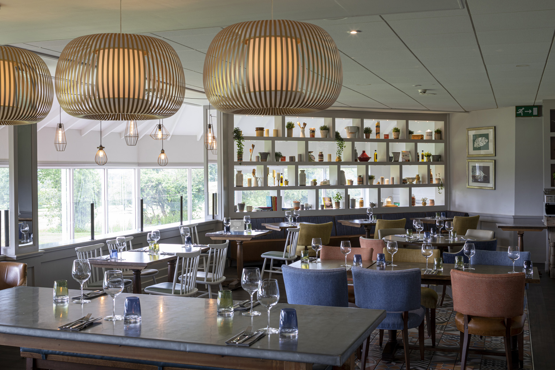 a restaurant with modern lights and shelves full of vases