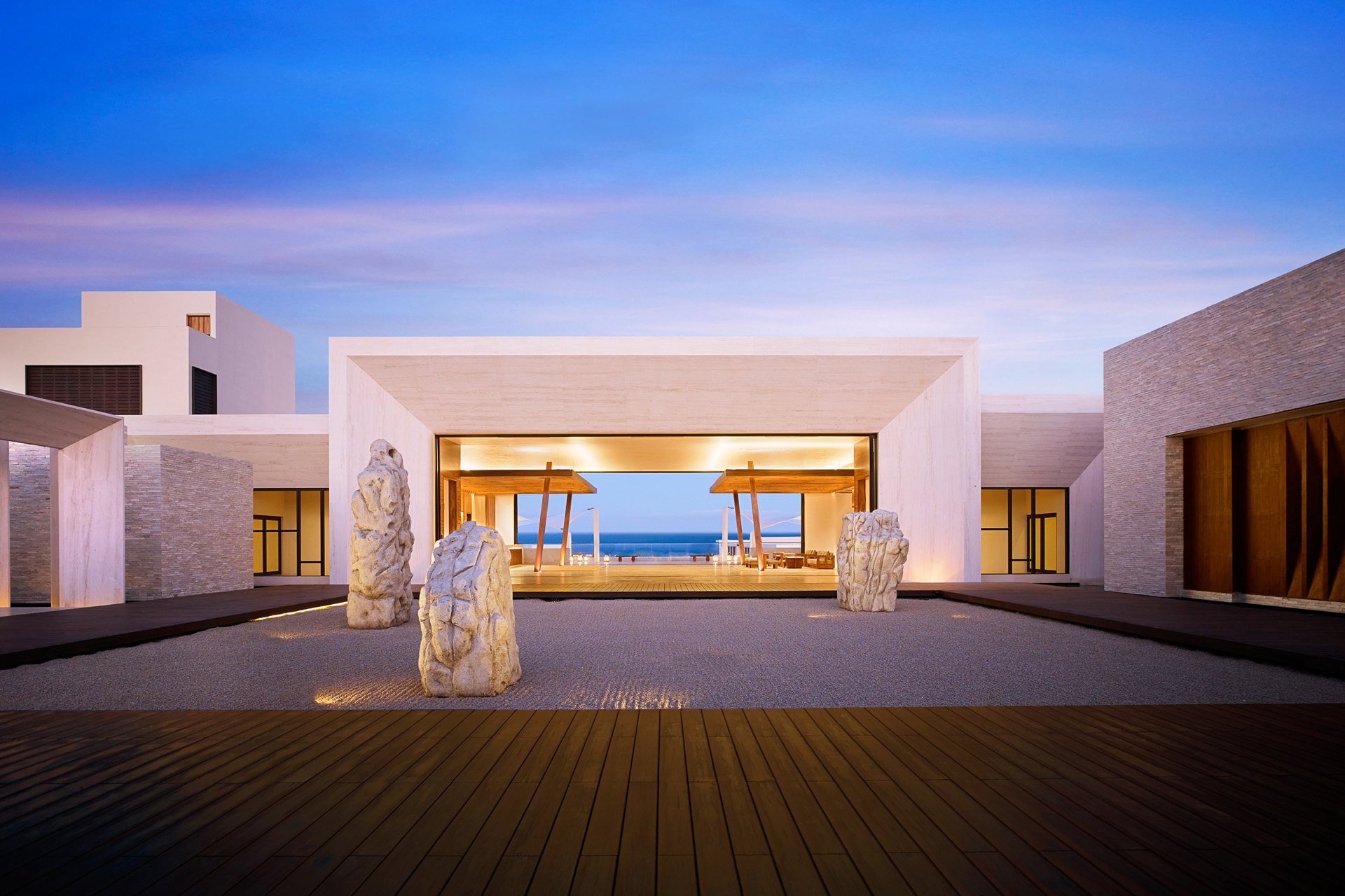 the lobby of nobu los cabos at dusk, with rocks and minimalist building design