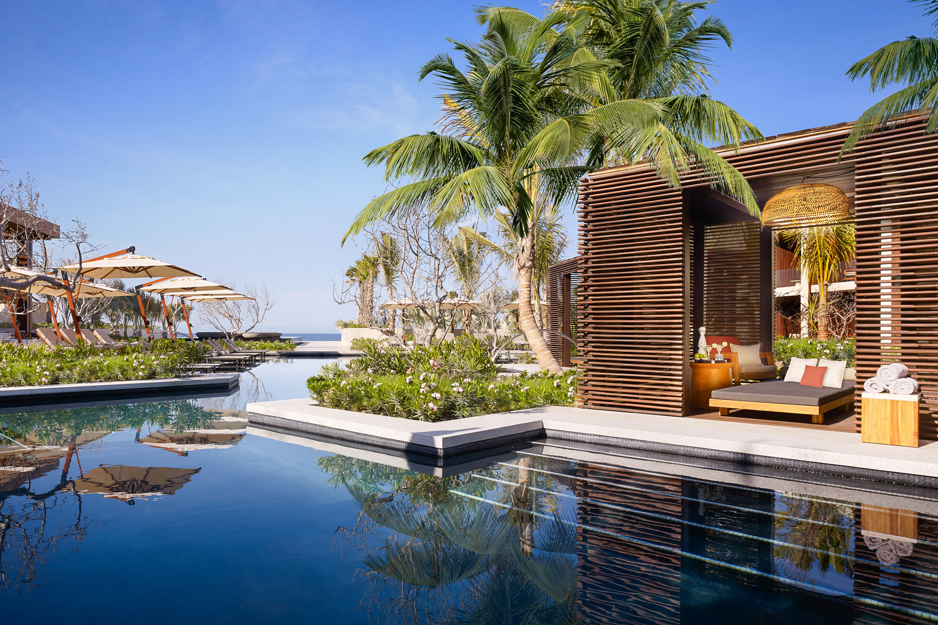 a swimming pool with palm trees and a clear blue sky