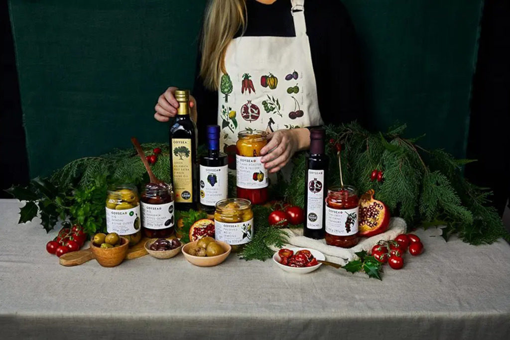 Woman stood over table spread with food and drink
