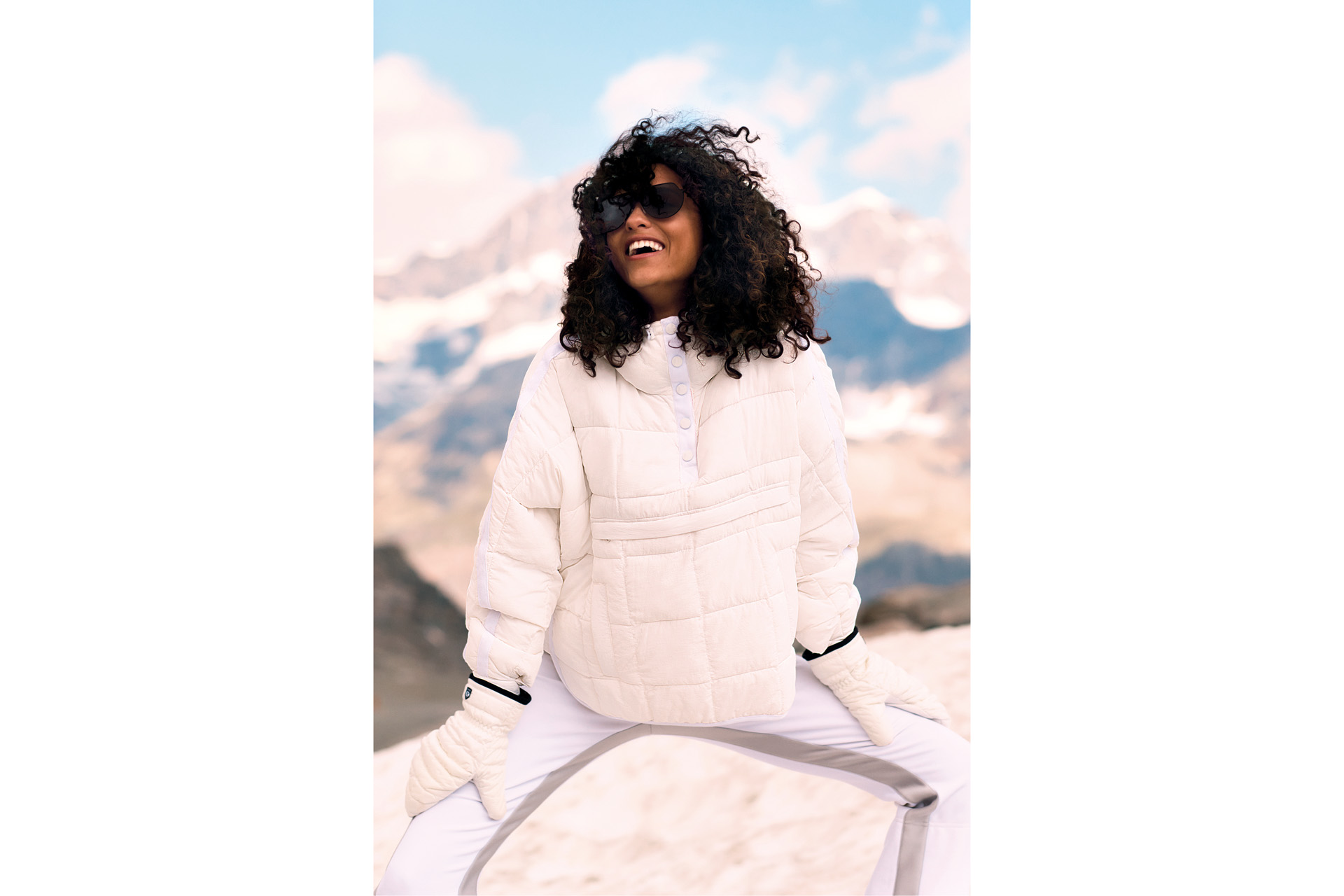 a woman in black sunglasses and a white puffer jacket