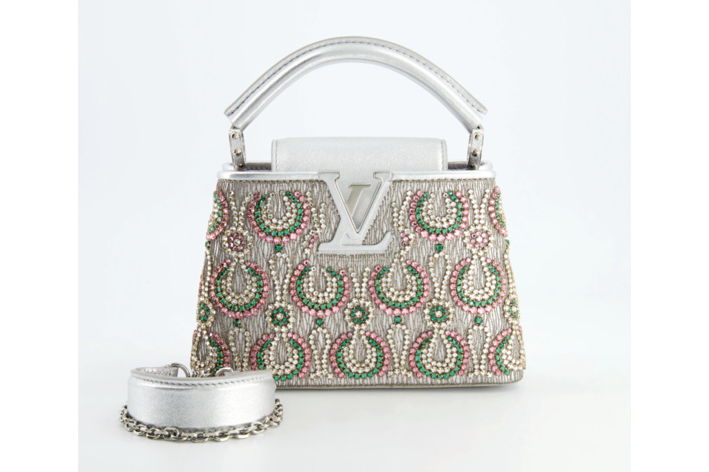 Silver handbag covered in gem stones and Louis Vuitton logo