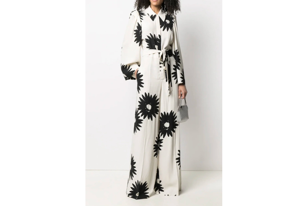 Woman in white jumpsuit with black flower print