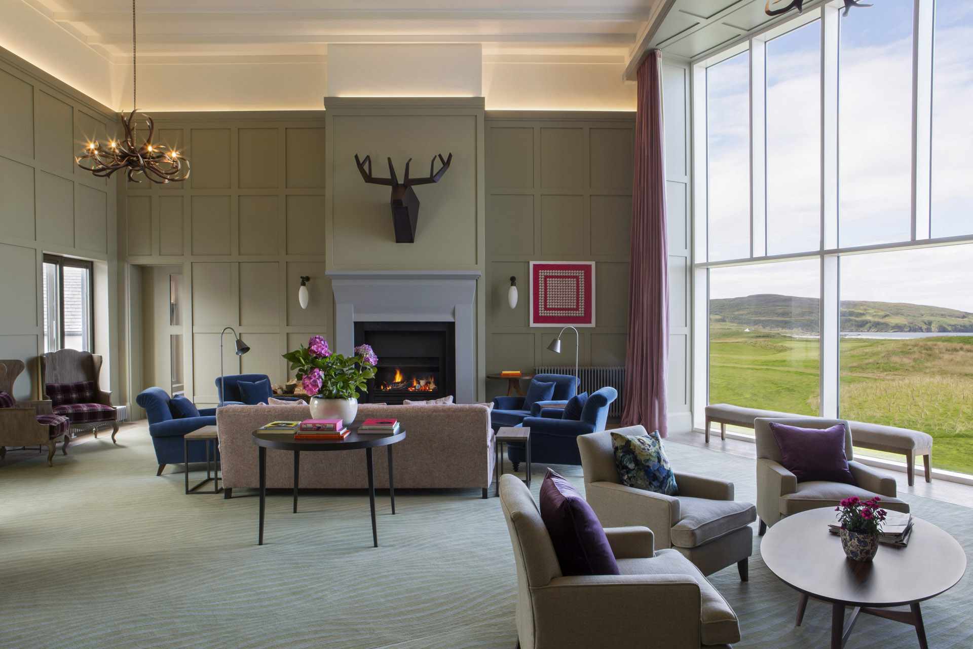 a cosy but spacious sitting room with a large window overlooking a golf course