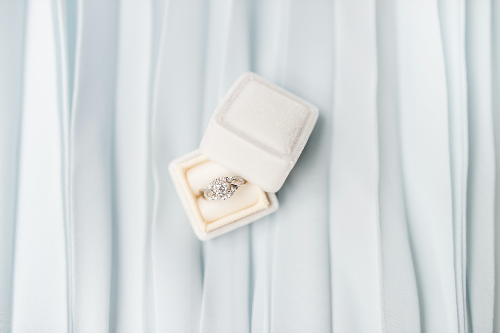 Engagement ring in cream box set on light grey fabric