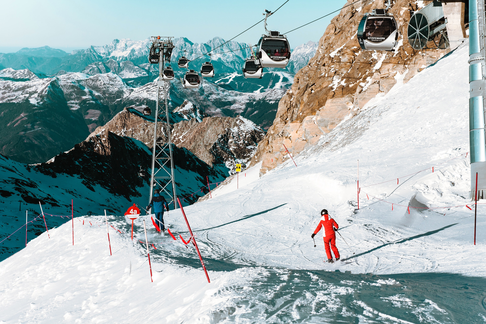 skiers and cablecars on a snowy mountain