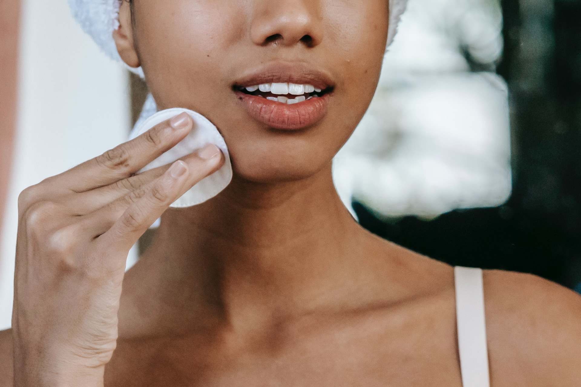 Close up of woman wiping her face with a cotton pad