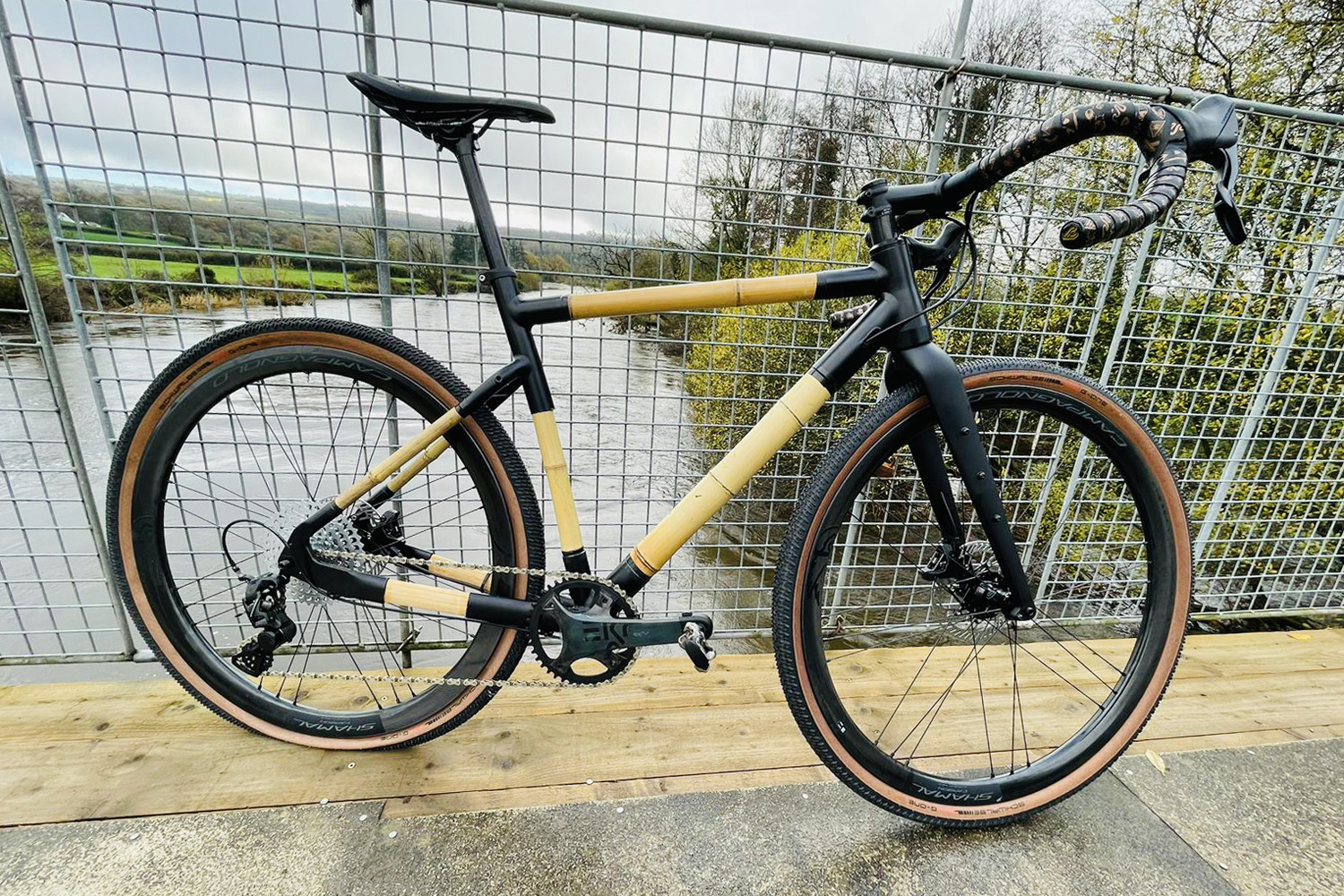 a bamboo bicycle against a railing