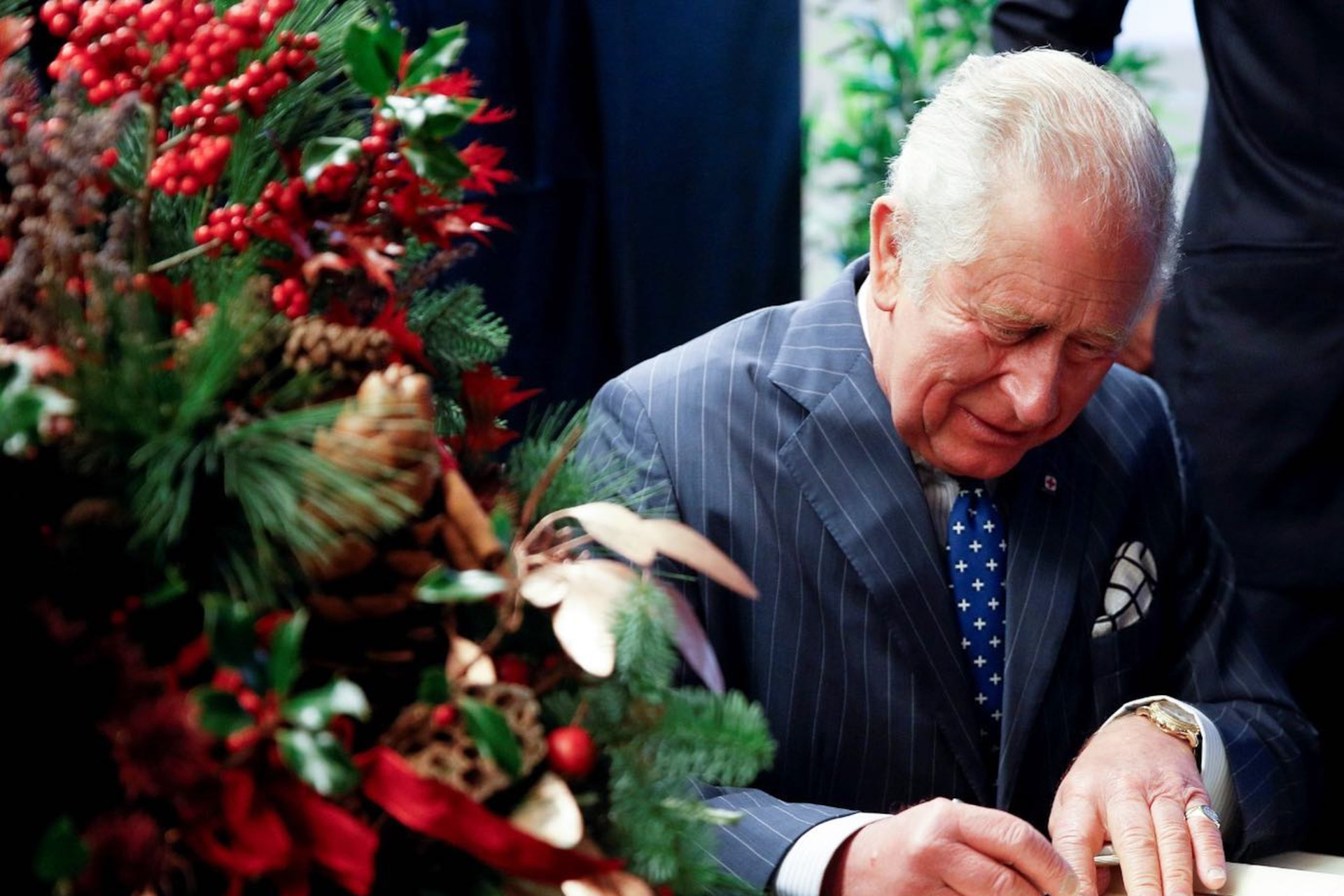 King Charles II signing documents next to Christmas tree